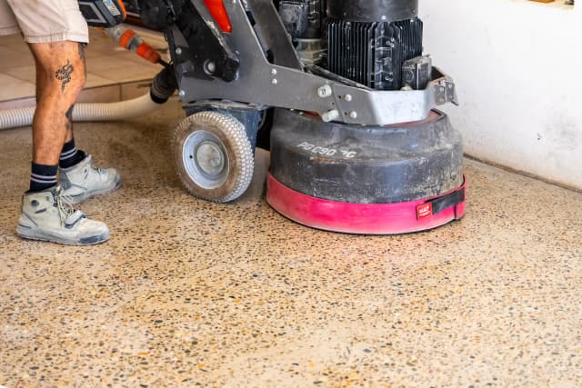 Mid-shot of the honed concrete floor with the Husqvarna grinding machine