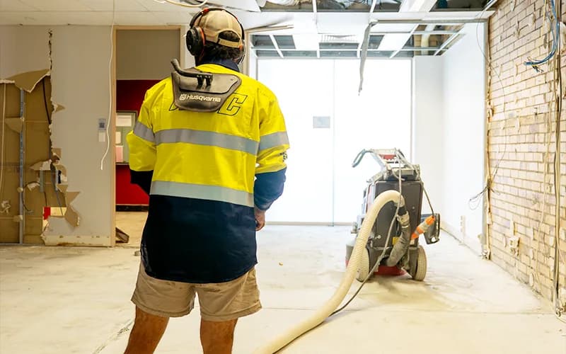 Husqvarna concrete grinder mid-completion on an indoor commercial concrete floor