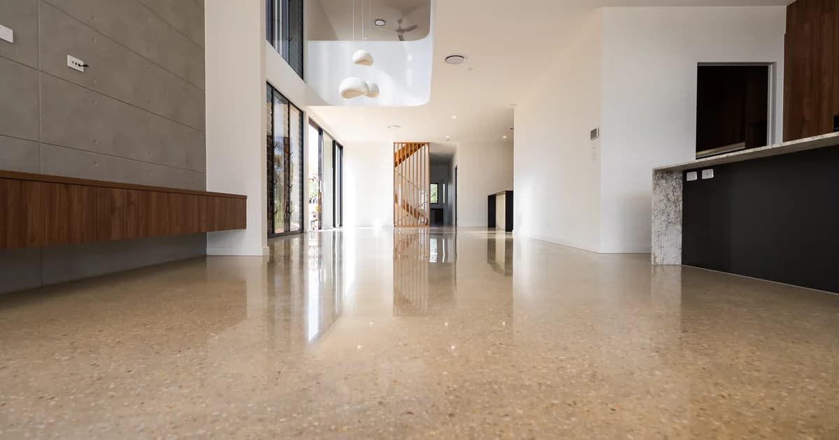 Wide open-plan living area with warm gold-aggregate polished concrete floor at a Holland Park home in Brisbane