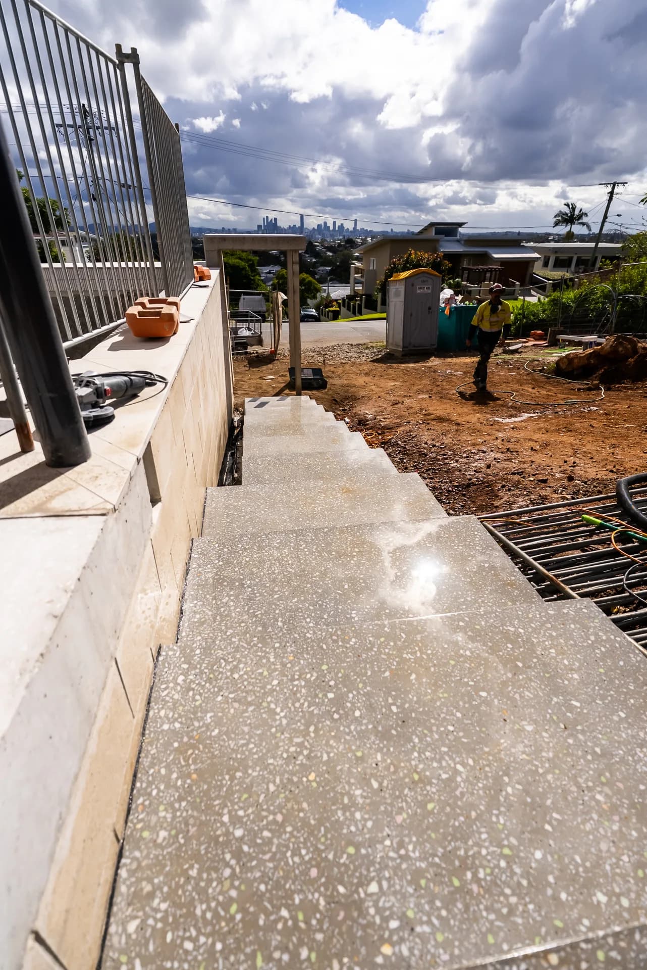 Polished concrete stairs beside a window framing the Brisbane CBD skyline