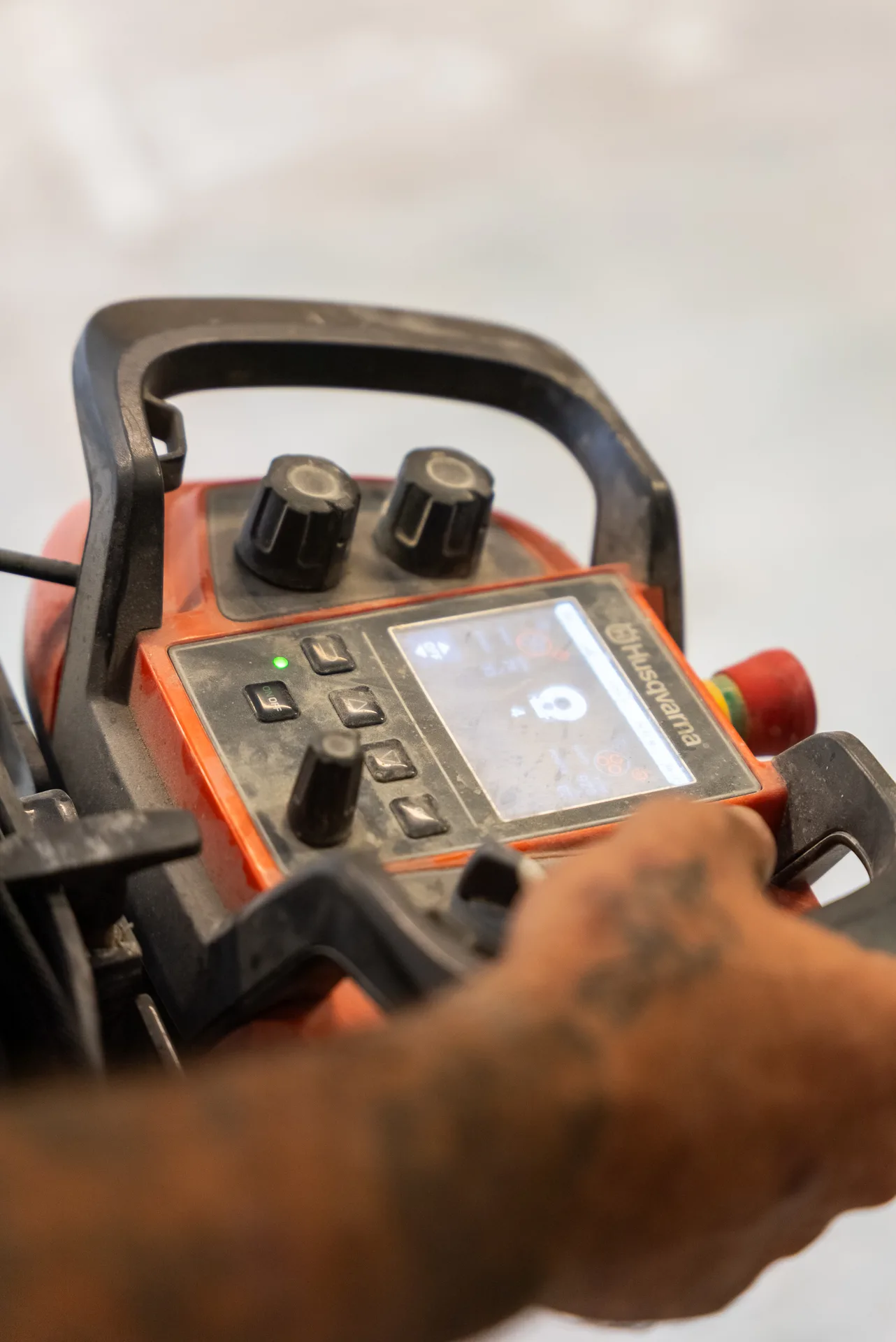 Husqvarna concrete grinder digital control panel with operator adjusting settings