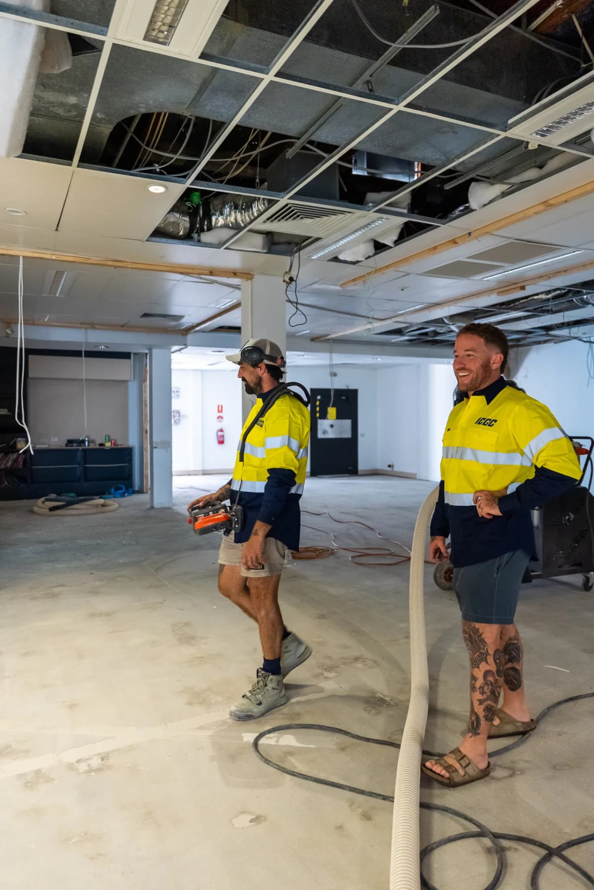 ICGC team walking across a large commercial space during concrete grinding preparation on the Gold Coast