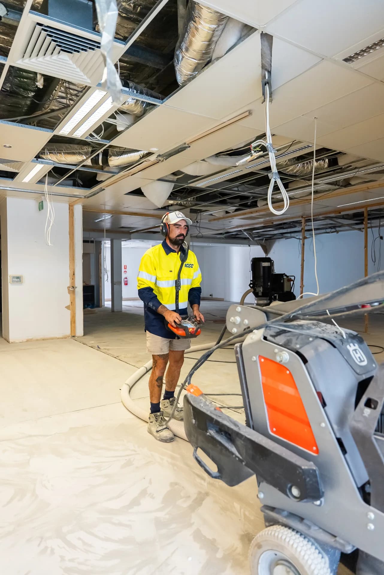 ICGC operator honing a concrete floor with industrial equipment in a commercial fitout space