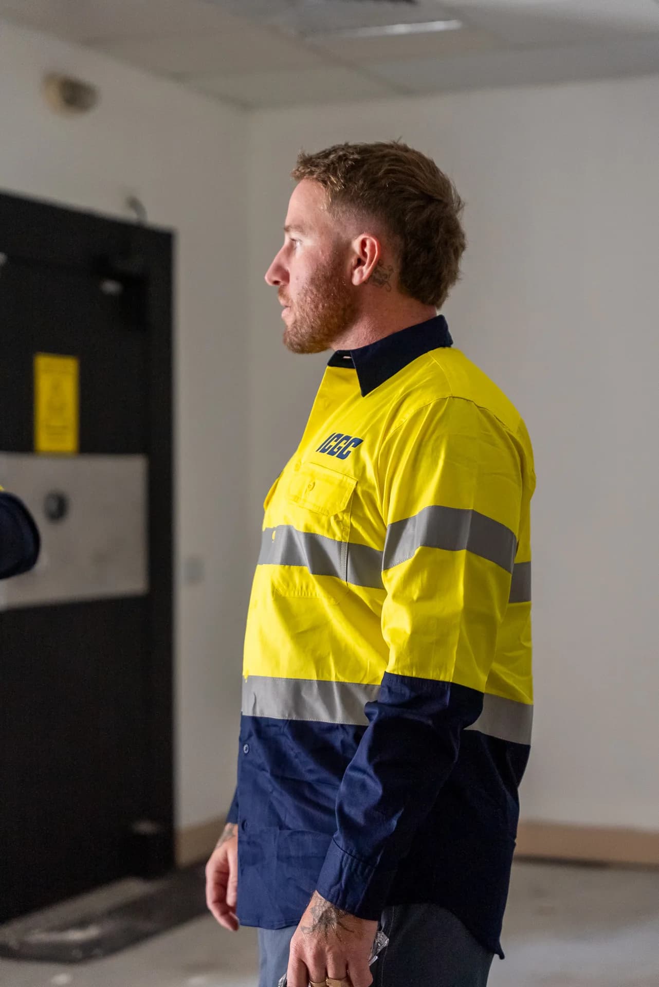 ICGC operator holding a Husqvarna edge grinder with planetary grinder in the foreground at a commercial site