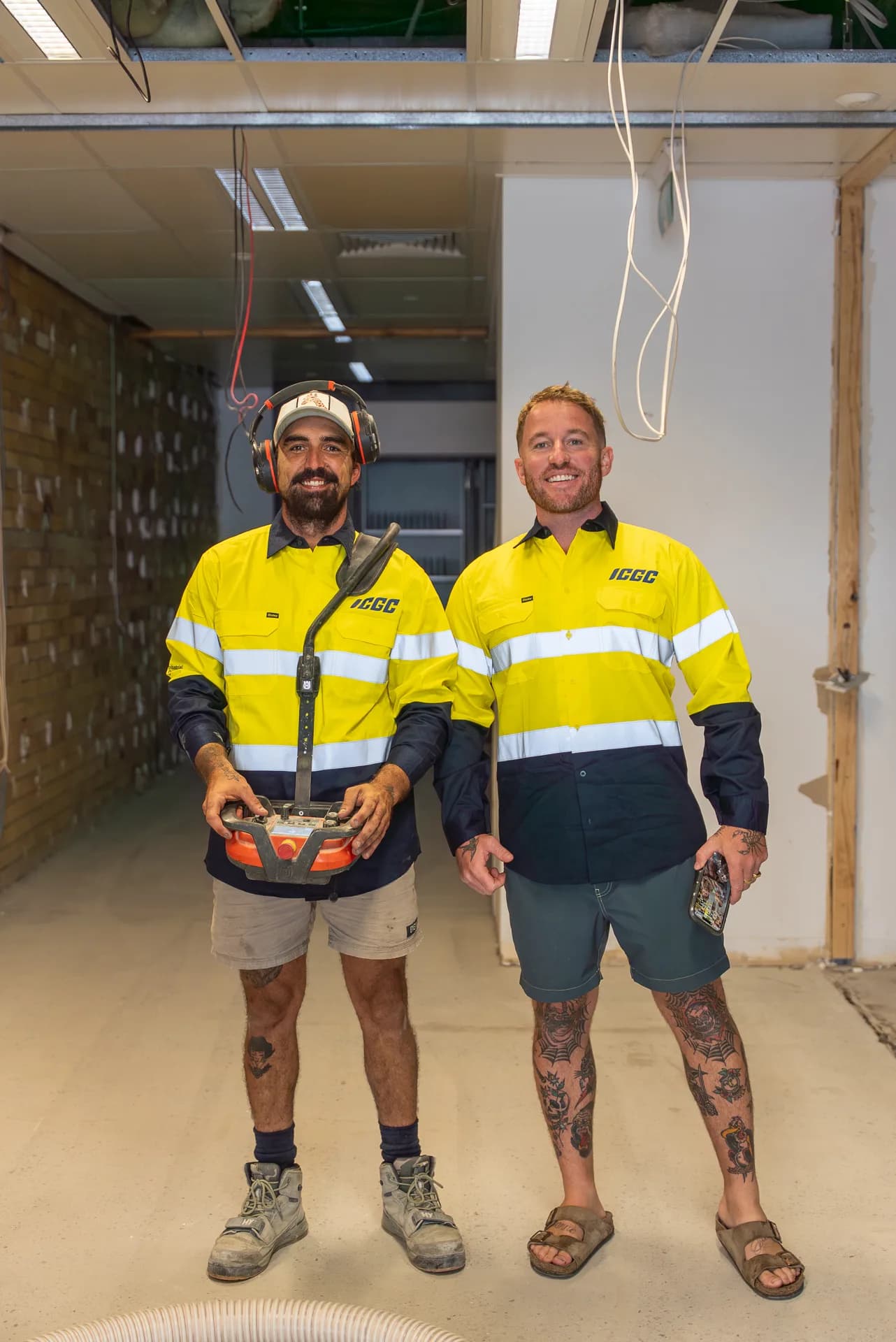 Two ICGC team members preparing a concrete slab for grinding in a Gold Coast commercial space